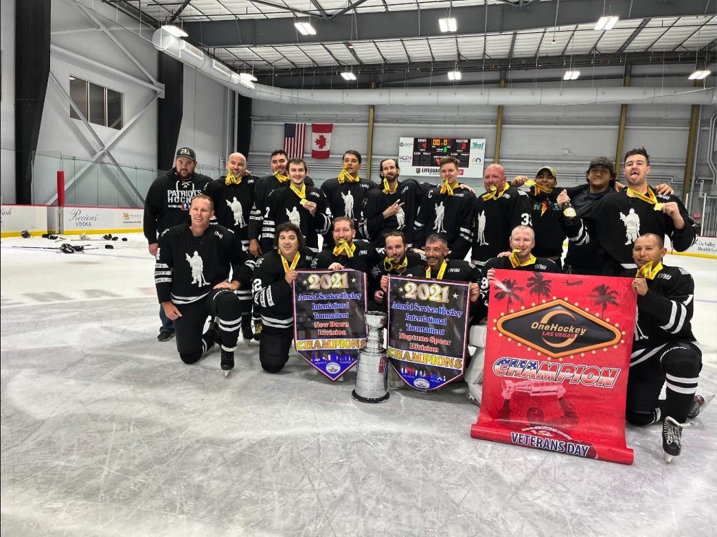 OneHockey adult tournament champions — Las Vegas — the Patriots team with two championship banners and the cup on Veterans Day