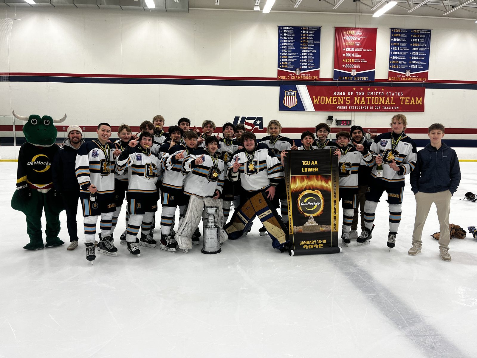 OneHockey youth champions celebrating on the ice with the trophy and mascot