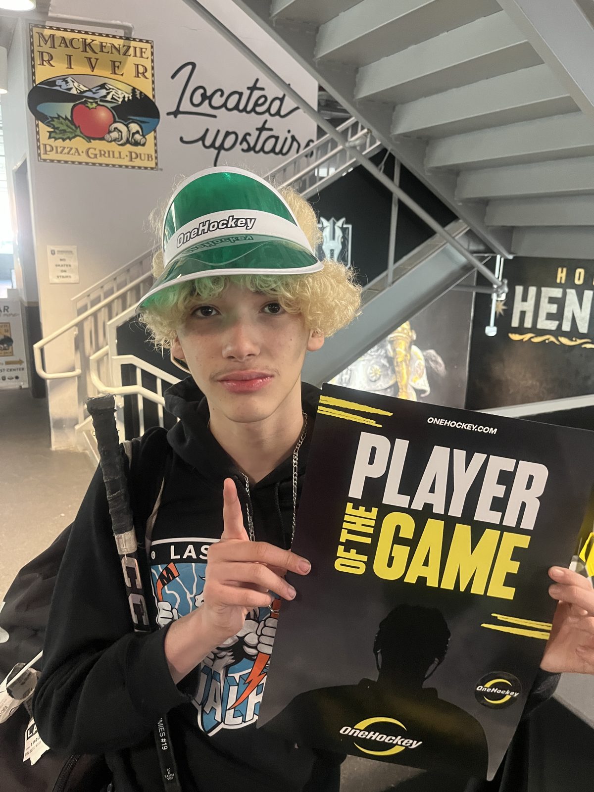 OneHockey youth player holding the Player of the Game award
